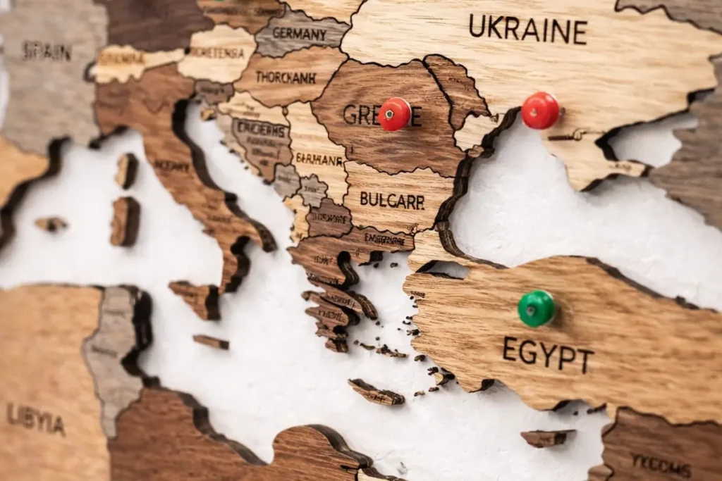 3d-wooden-world-map-smokey-close-up-pins - Modern Wall Art Guides Close-up of a 3D wooden world map showing layered wood depth with travel pins inserted